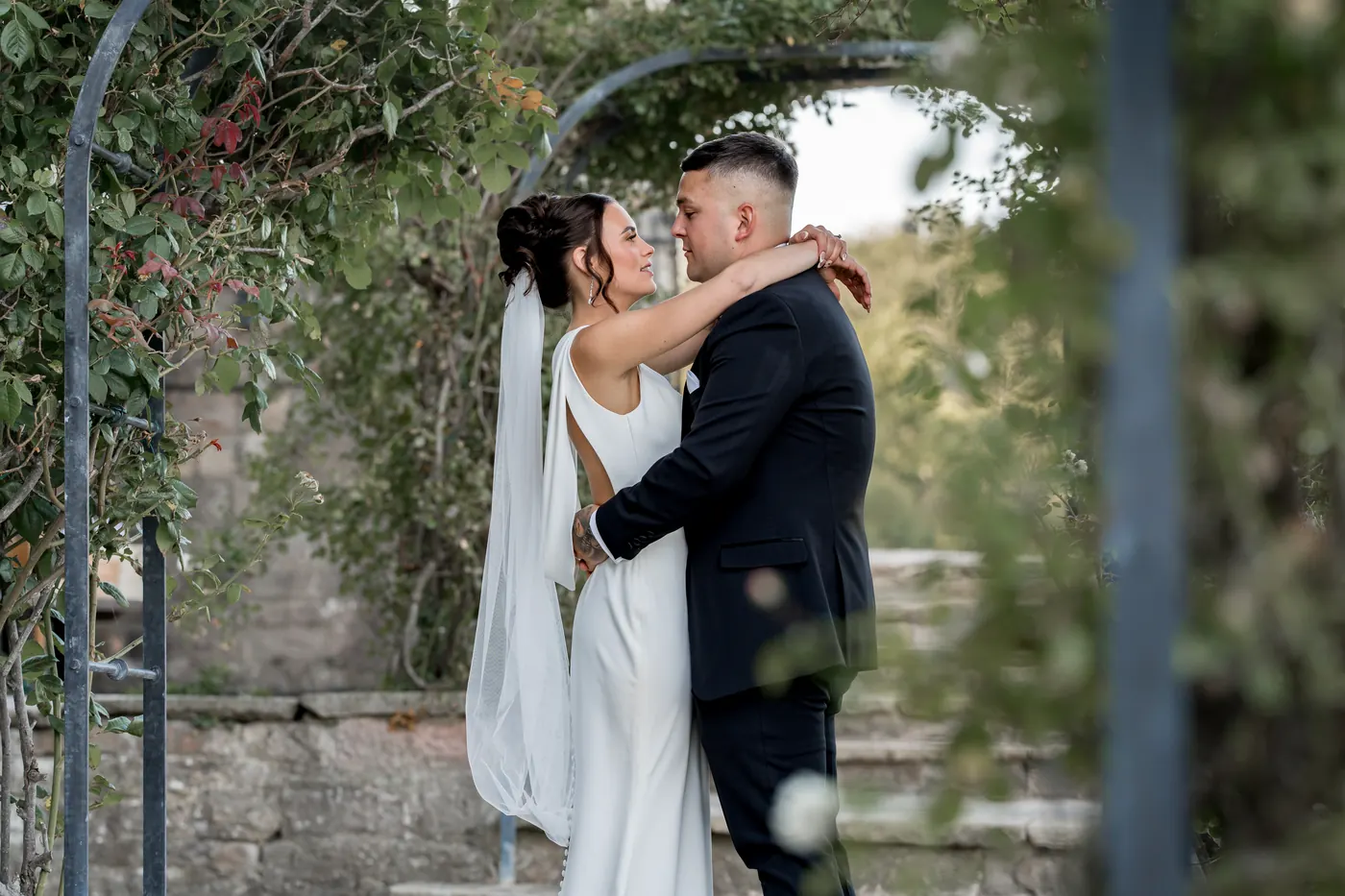 Couple kissing beneath a floral archway