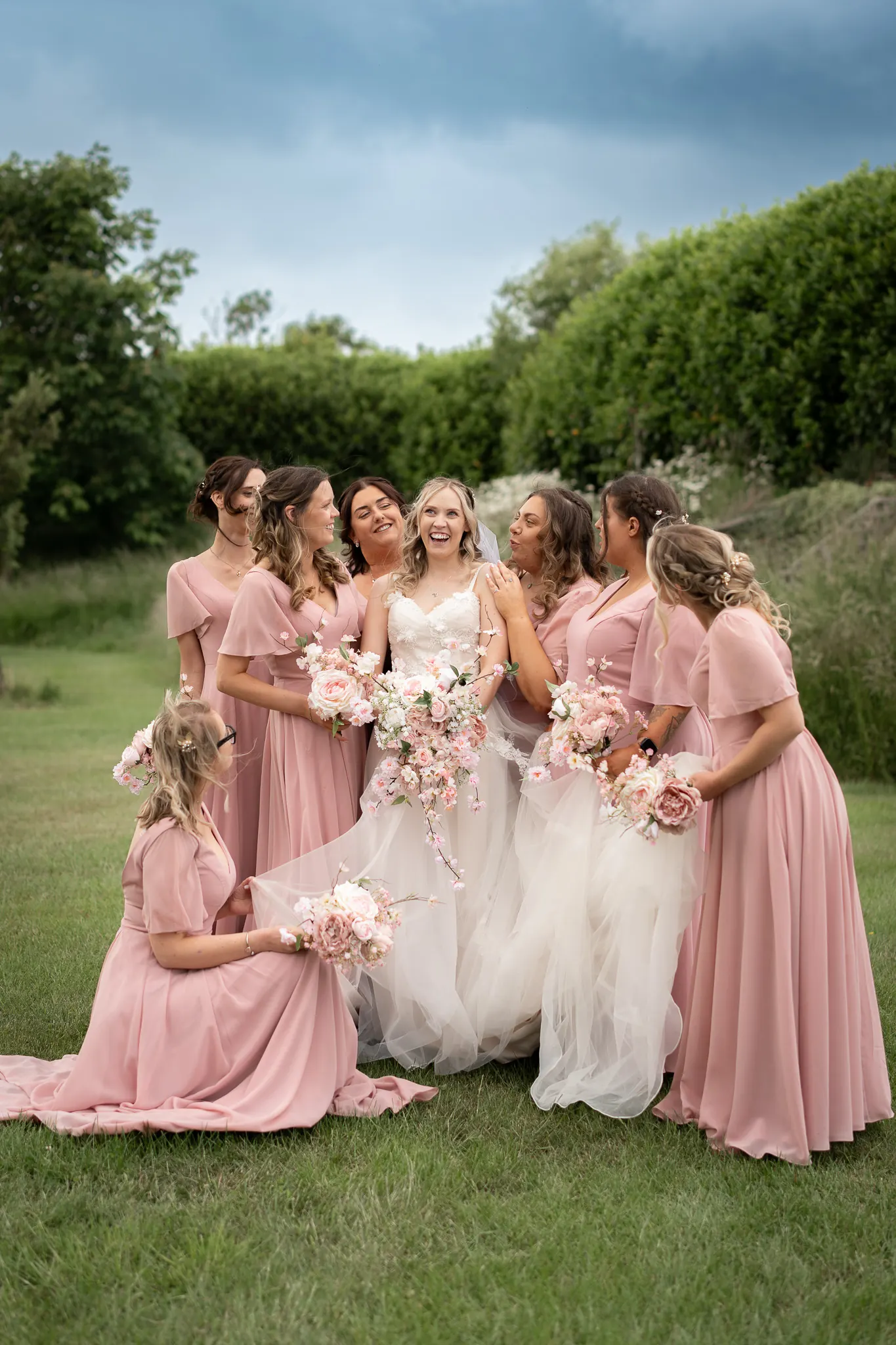 Bridesmaids in pink dresses laughing together