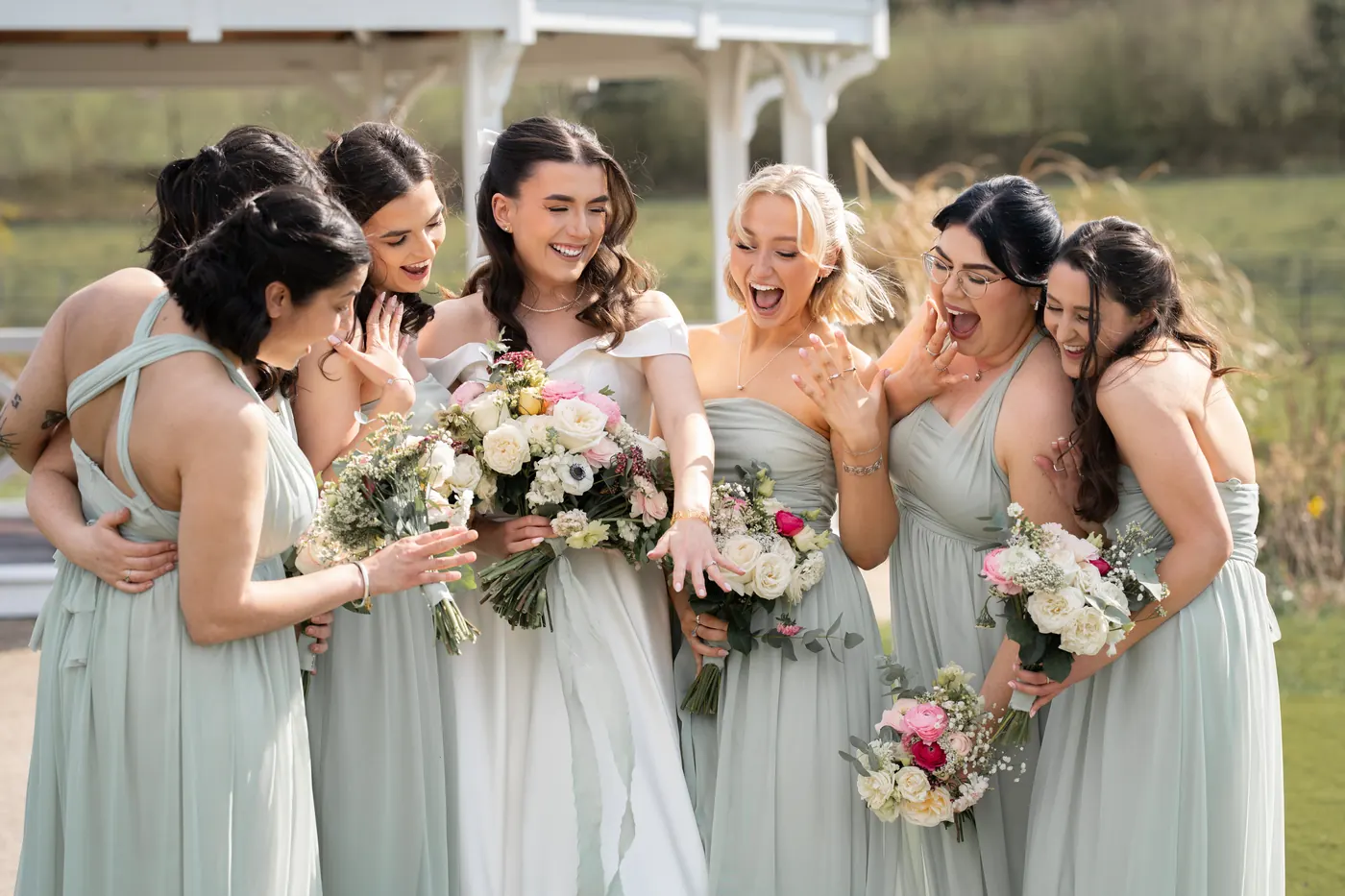 Bridesmaids laughing together with their bouquets