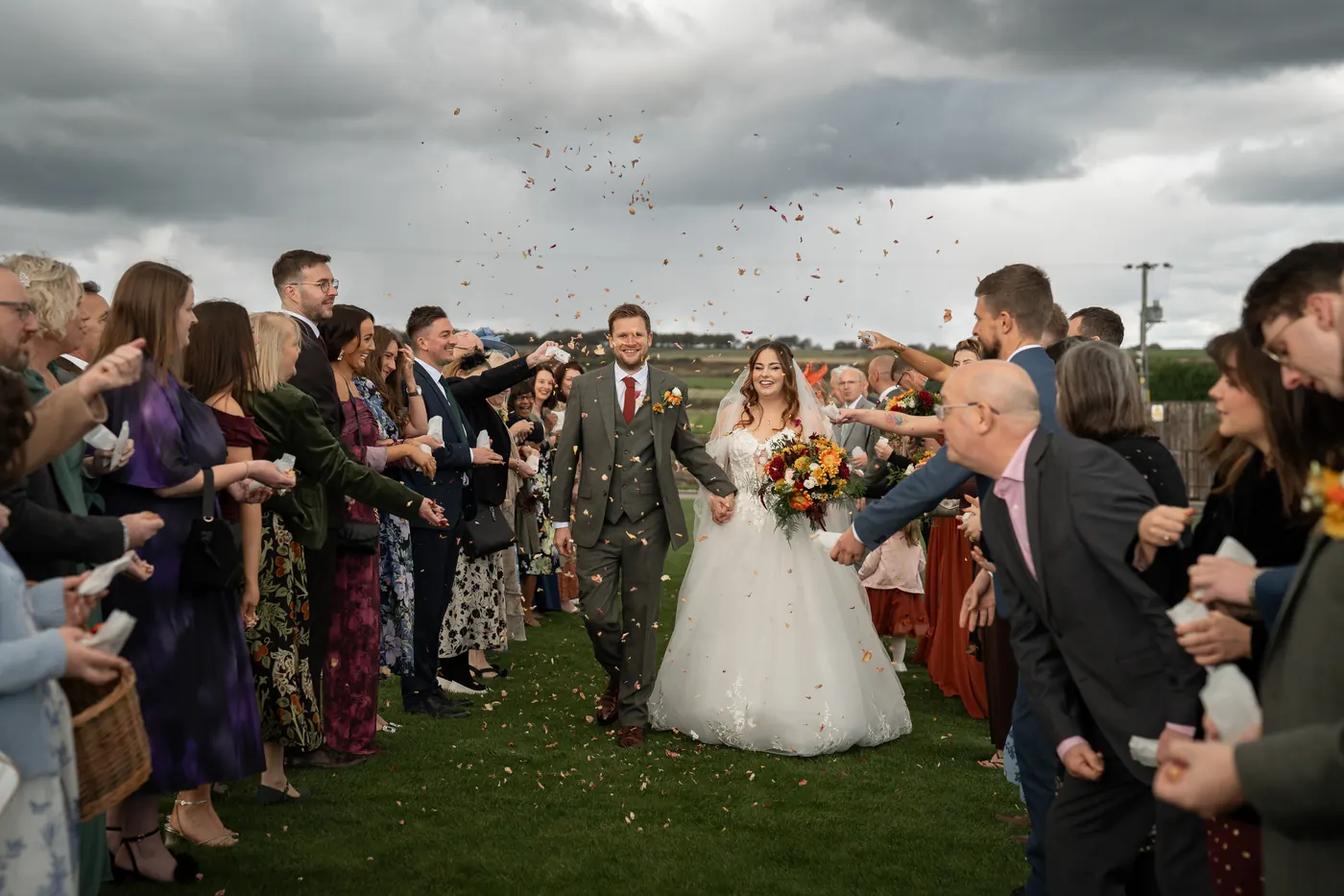 Wedding party throwing confetti over the couple