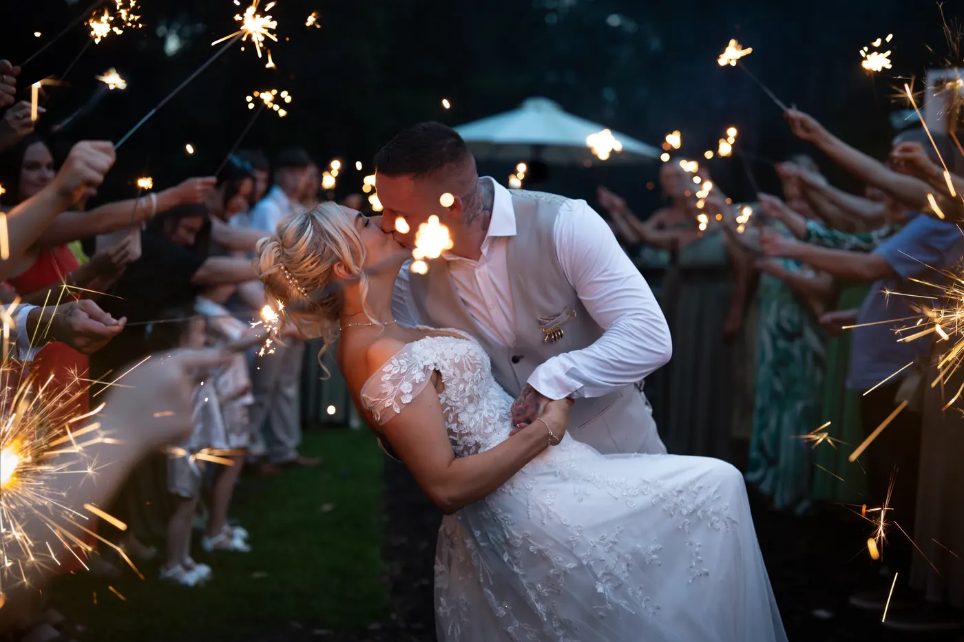 Couple kissing under sparklers at night